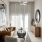  3 Bedroom Luxury Apartments in Maitland FL - Perla Gem Lake - Furnished Living Room with High Ceilings, a Leather Couch, an Armchair, Wooden Cabinet, Side Table, Beige Walls, Mounted Mirror, and a Large Window