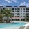 Pet-Friendly Luxury Apartments in Maitland, FL - Aventon Gem Lakes - Pool with Palm Trees and Lounge Chairs